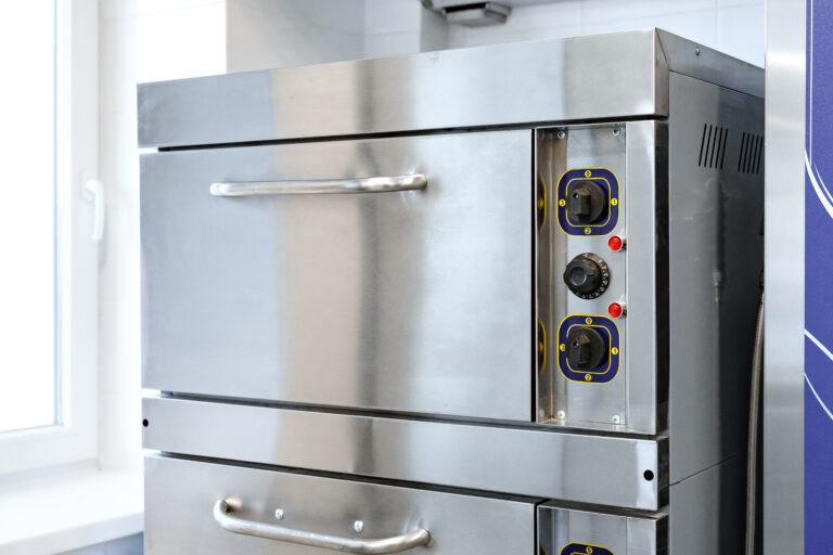 A sleek stainless steel oven installed in a bright kitchen, featuring two cooking compartments and user-friendly controls for efficient meal preparation.